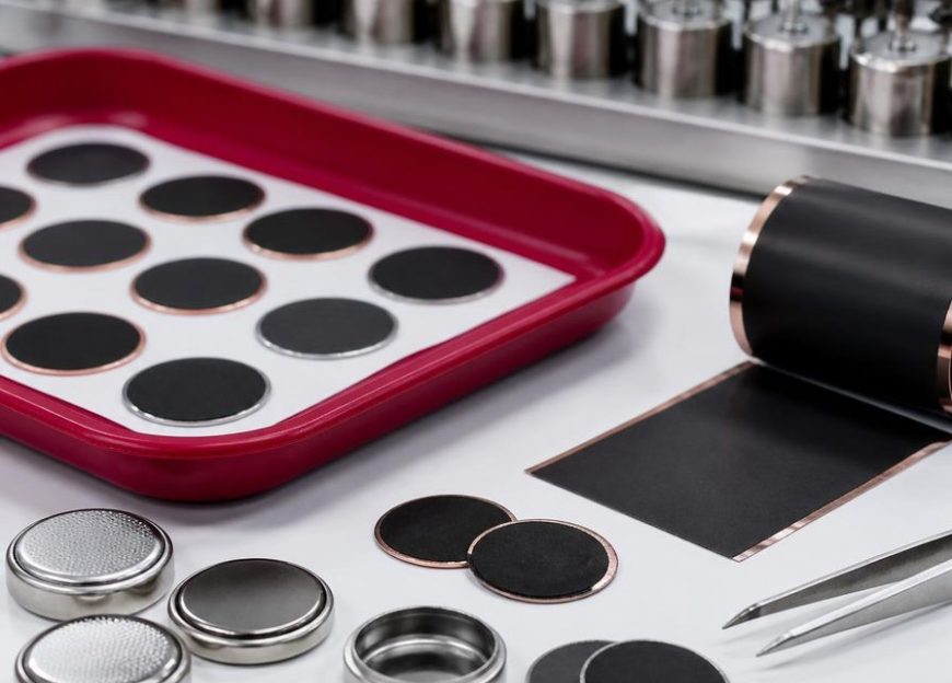Coin cell batteries and electrode discs in a lab tray