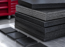 Stack of layered composite test panels and cut coupons on a cart