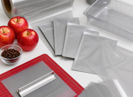 Coated packaging films and blank pouches beside apples and coffee beans